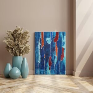 Abstract blue canvas wall art with copper accents leaning against a beige wall beside turquoise vases and dried foliage.